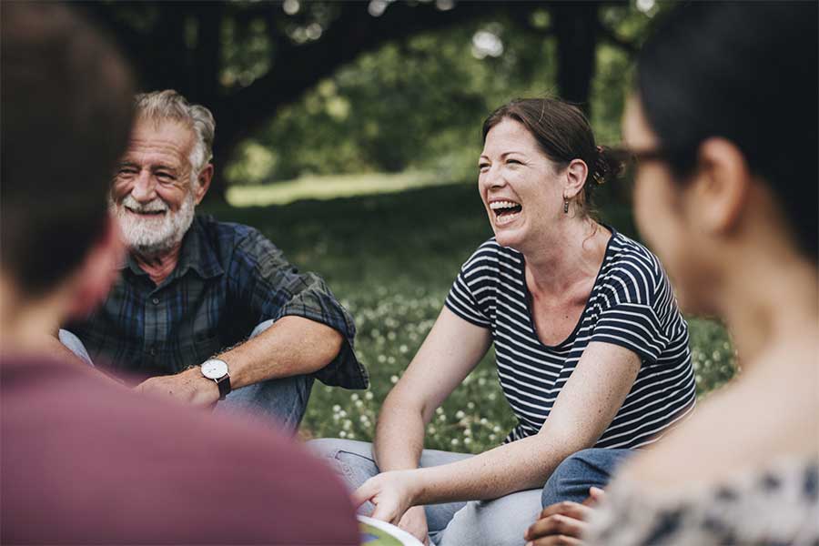Happy residents sitting in green space together