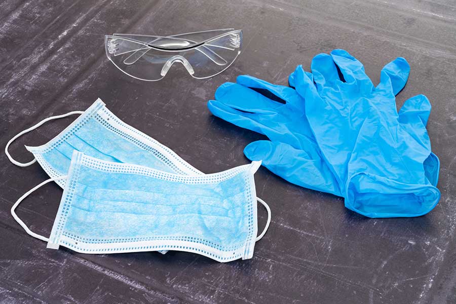 Surgical gloves, goggles and face mask on table