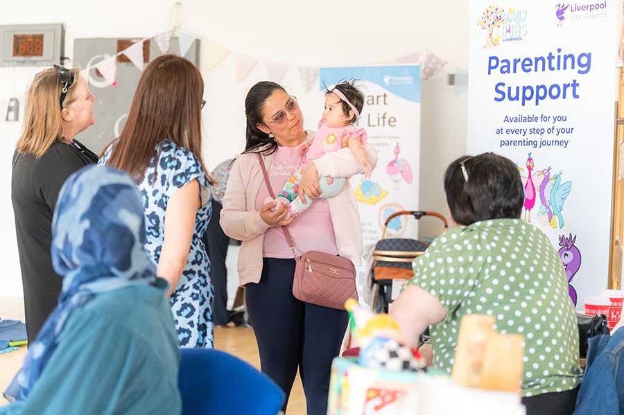 Parent holding baby daughter at parenting support event